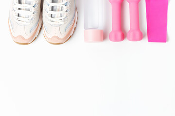 Sneakers, bottle of water and dumbbells on white background