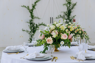 Flowers, plates and glasses served for dinner in restaurant.