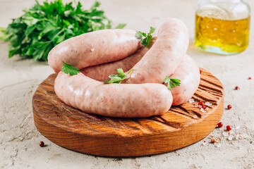 Raw chicken sausage for grilled on wooden cutting board with parsley. - obrazy, fototapety, plakaty