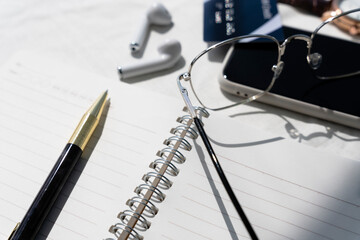 Work space office concept on white table with book, pencil, eyeglasses, smartphone.