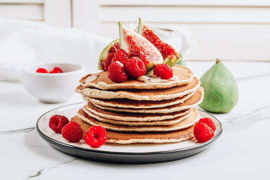 Homemade classic american pancakes with almond, fresh raspberries and figs