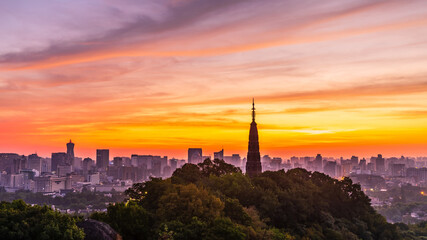 Fototapeta premium Ancient Baochu Pagoda.Chinese traditional architecture and modern city skyline in Hangzhou at sunrise,China.