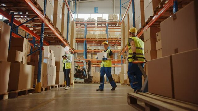 Retail Warehouse full of Shelves with Goods in Cardboard Boxes, Workers Scan and Sort Packages, Move Inventory with Pallet Trucks and Forklifts. Product Distribution Logistics. Slow Motion Ground Shot