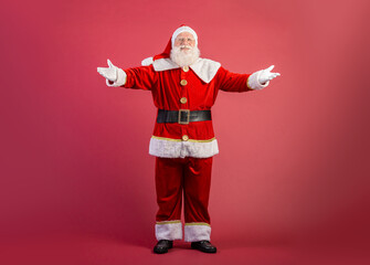 Santa Claus on red background with copy space. Presenting.