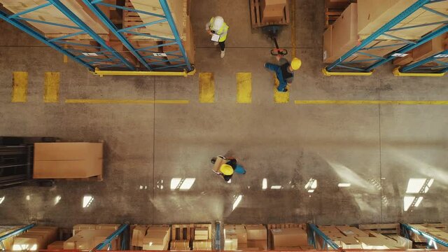 Top-Down View: In Warehouse People Working, Forklift Truck Operator Lifts Pallet with Cardboard Box. Logistics, Distribution Center with Products Ready for Global Shipment, Customer Delivery