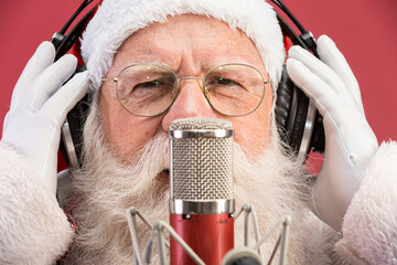 Santa Claus singing or speaking in a studio microphone. Merry Christmas. Broadcaster. Announcer....