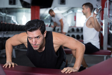 Muscular man practicing healthy lifestyle, performing push-ups during training