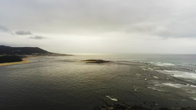 Aerial View of a Beach with Mountains in the Background - Zooming Shot 4K