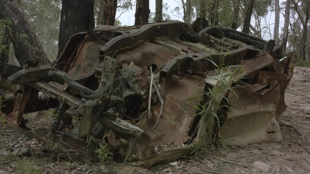 Abandoned flipped car in Australian bushland front on low angle truck right.