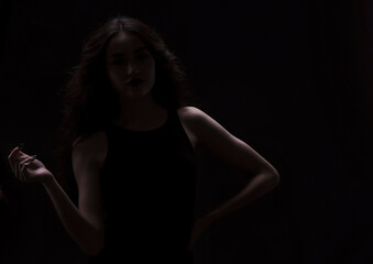 Silhouette of a beautiful, slender brunette in a black dress