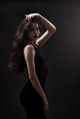 Fototapeta na wymiar Silhouette of a beautiful, slender brunette in a black dress