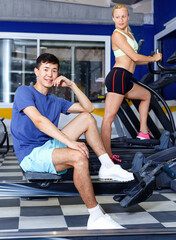 Fototapeta na wymiar Portrait of satisfied athletic cheerful positive male resting during workout in fitness club