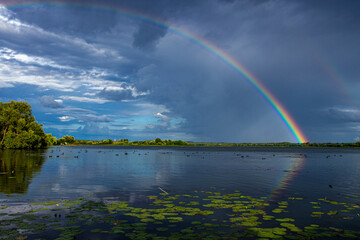 Rainbow in the sky and reflection in the water