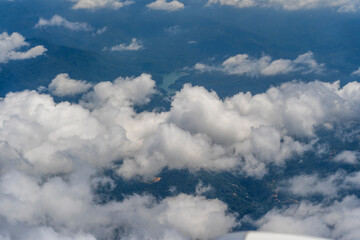 Naklejka premium Flying above the earth and above the clouds in territory Kota Kinabalu, island Borneo, Malaysia. Airplane window view.