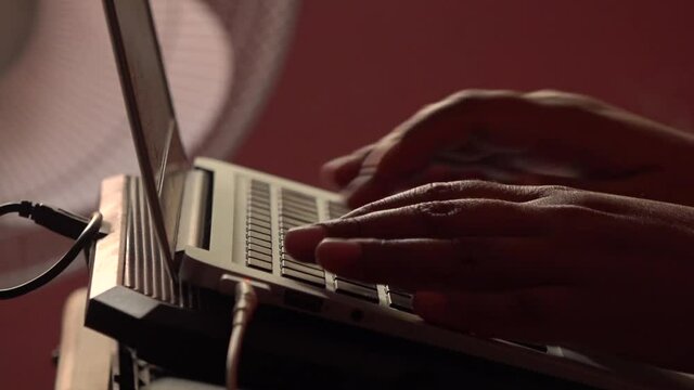 Hands typing on a portable computer.