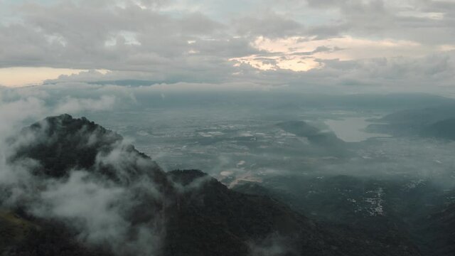 Drone aerial flying high over the clouds, view to lake amatitlan and mountains in Guatemala