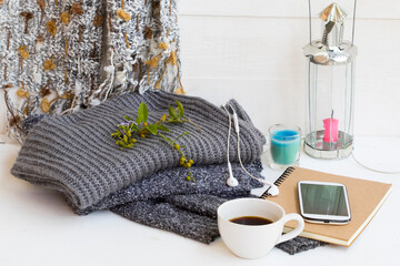 notebook ,mobile phone ,coffee and knitting  wool sweater ,scarf of lifestyle woman relax in winter season decoration on background white wooden