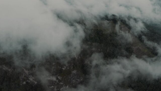 Drone aerial flying over the clouds towards a mountian and rainforest in Guatemala