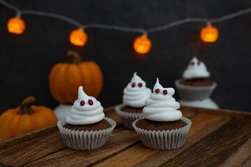 Halloween ghost cupcakes , homemade sweet chocolate muffins with meringue ghost