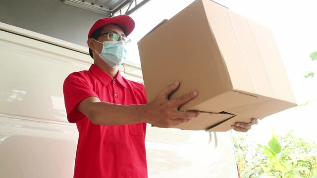 Asian young man delivery in red uniform with packages