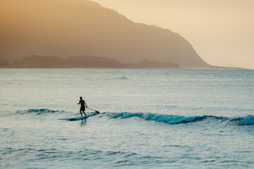 Paddleboard surfer SUP athlete surfer silhouette on Hawaii Beach. Outdoor sports lifestyle.