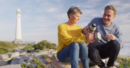 Couple drinking coffee by the sea - Powered by Adobe