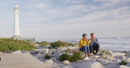 Couple drinking coffee by the sea - Powered by Adobe