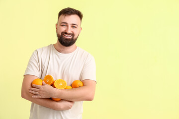 Man with oranges on color background