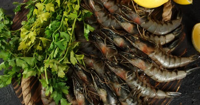 Raw shrimp with herbs and lemon on the tray rotate. 