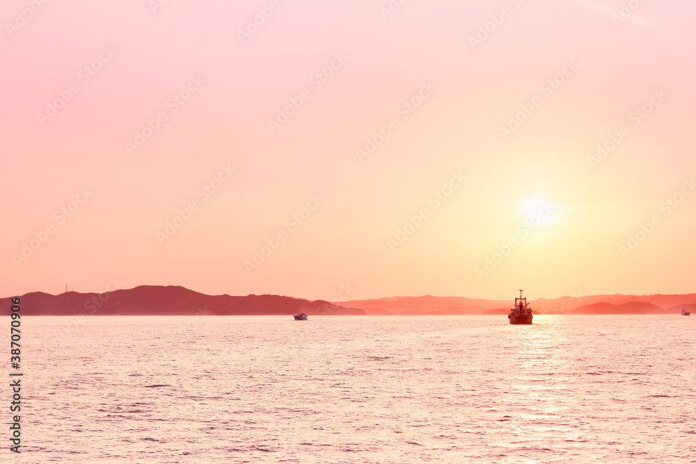 Wall mural Peace pink ocean view with rock mountain, cliff, open water and island in a quiet afternoon sunset in Japan, Seto Inland sea.