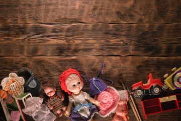 Old retro girl children toys on the brown wooden table background.