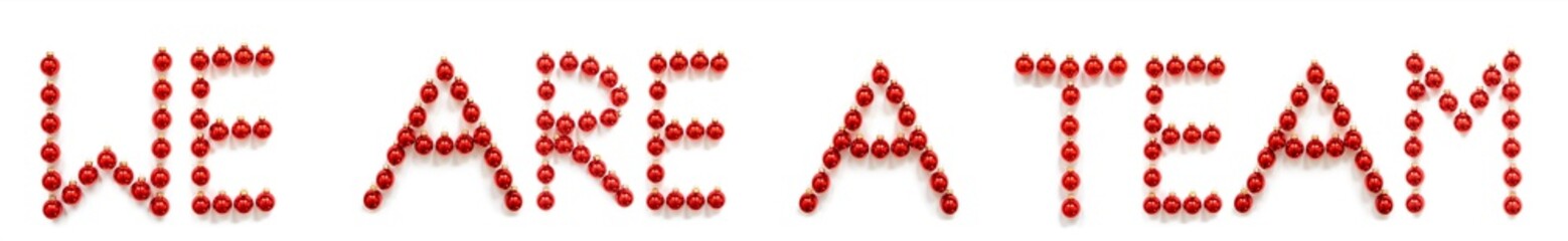 Red Christmas Ball Ornament Building English Word We Are A Team. Festive Christmas Decoration. White Isolated Background