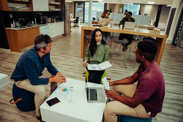 Diverse team of partners gather together to discuss work for the week before meeting in conference room with manager and colleagues 