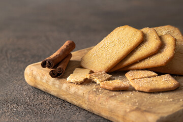 Stack of Cinnamon sugar  crackers on wooden plate on background.