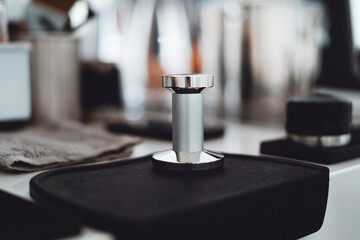 Coffee tamper placed on the table in the coffee shop.