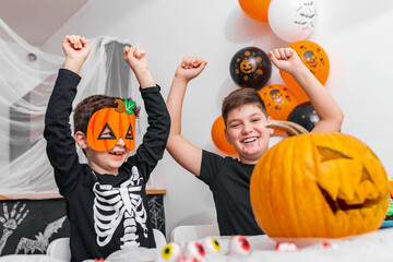 Happy Halloween! Attractive young boy with his big brother are preparing for Halloween party....
