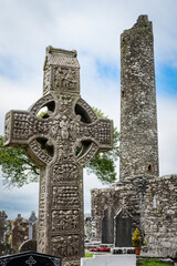 Drogheda, Ireland - July 15, 2020: View of Muiredach's high celtic cross and round tower at early Christian monastic settlement Monasterboice founded in 5th century. - 387075901