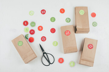 Preparation of christmas advent calendar. Eco paper bags with presents. Sustainable christmas