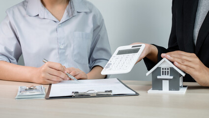 Fototapeta premium A real estate agent with a home model is talking to clients about renting a house and buying home insurance and contracting the contract after the formal negotiation is completed