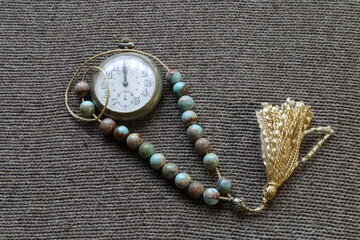 pocket watch and rosary on the table