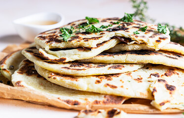 Indian homemade traditional flatbread with fresh parsley and olive oil. Chapati, roti or naan Indian crispy flatbread.