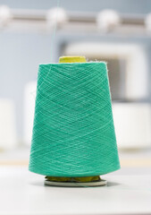 green cotton yarn at work on a knitting machine