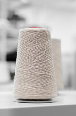 white yarn in the process of working on a knitting machine in production