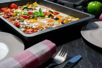 oven baked eggs with vegetables on a baking tray