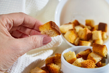 Square toasted pieces of homemade delicious rusk, hardtack, Dryasdust, zwieback in a plate on a white tablecloth.