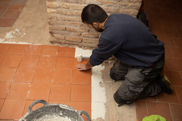bricklayer worker laying tiles on floor