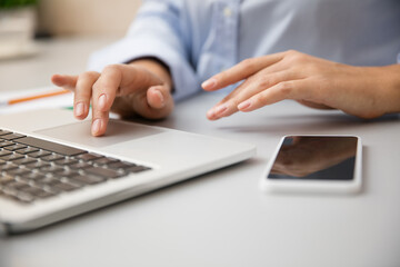 Close up of female hands typing. Remote working from home. Workplace in home office with PC, devices and gadgets. Concept of distance learning, isolation, female business, shopping online, conference.