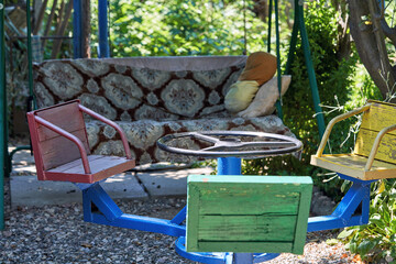 Old iron carousel with colorful wooden seats