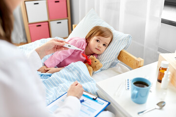 healthcare, medicine and people concept - close up of doctor with thermometer measuring temperature of little sick girl lying in bed at home