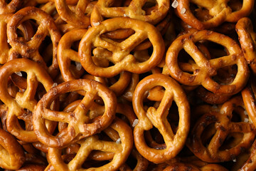 Tasty cracker pretzels on whole background, close up
